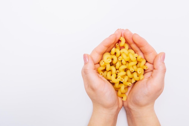 Hands holding macaroni Pasta in female hands