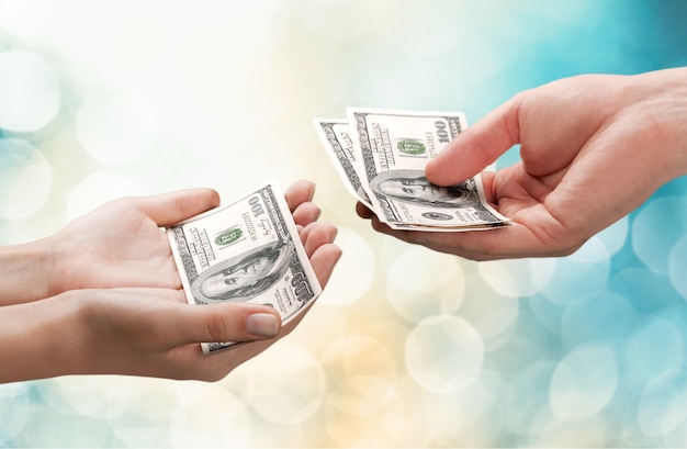 Hands holding one hundred dollars banknote over background