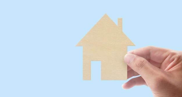 Hands holding paper house family home