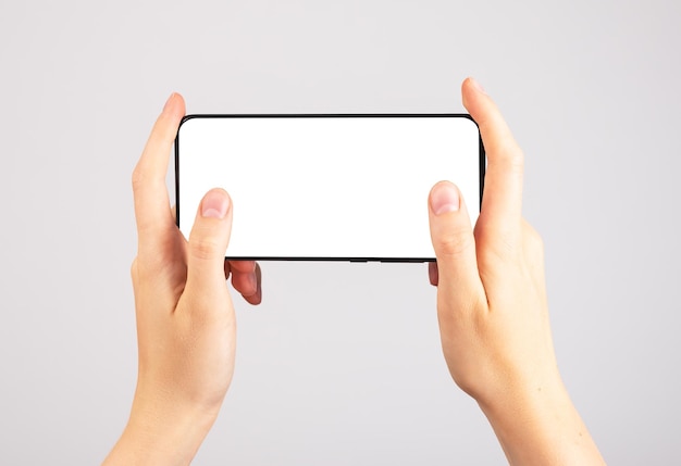 Hands holding phone mockup in horizontal position Woman using smartphone for playing games Mobile gaming template with blank display