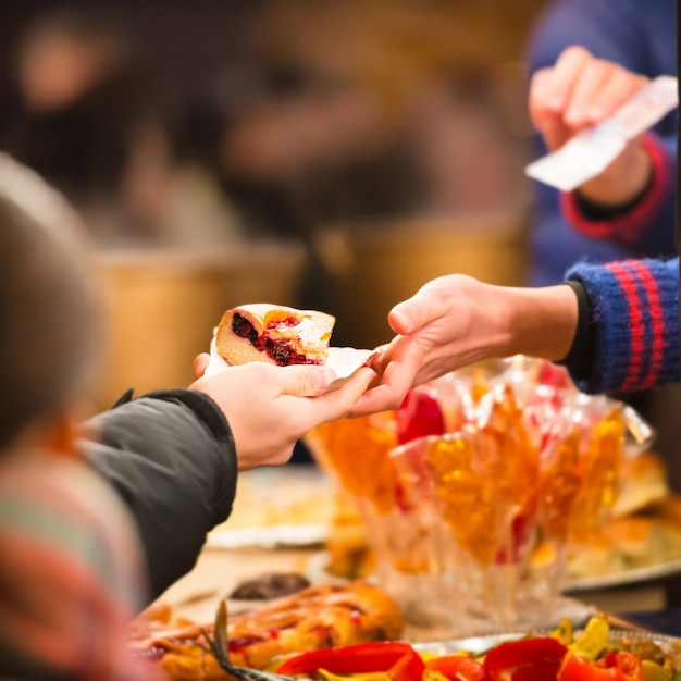 Hands holding piece of apple pie on the street food festival