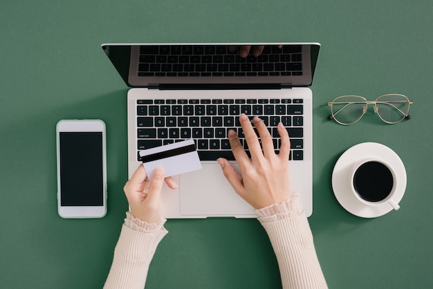 Hands holding plastic credit card and using laptop. Online shopping concept