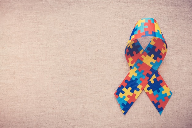 Hands holding puzzle ribbon for autism awareness