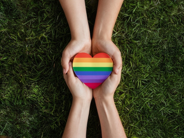 Photo hands holding a rainbow heart symbolizing lgbtq pride