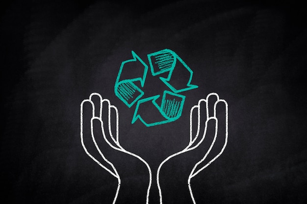 Hands holding a recycling symbol on a blackboard