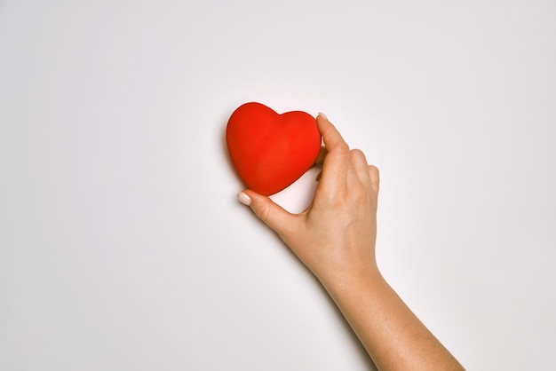 Hands holding red heart health care love organ donation praying concept