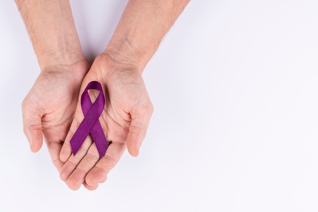 Hands holding ribbon as symbol for awareness