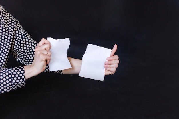 Hands holding a sheet of paper torn into two parts