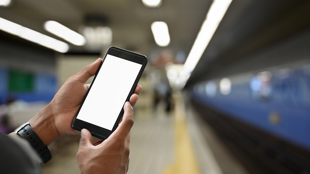 Hands holding smartphone isolated screen in subway metro train station at Japan.