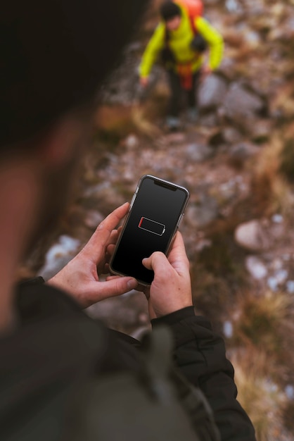 Hands holding a smartphone outdoors