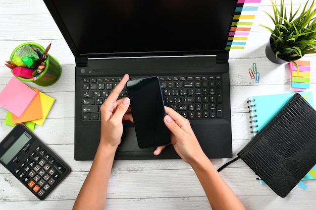 Hands holding a smartphone with black screen