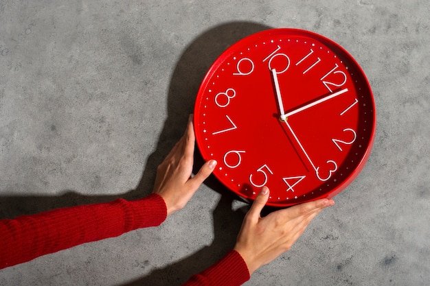 Hands holding wall clock still life