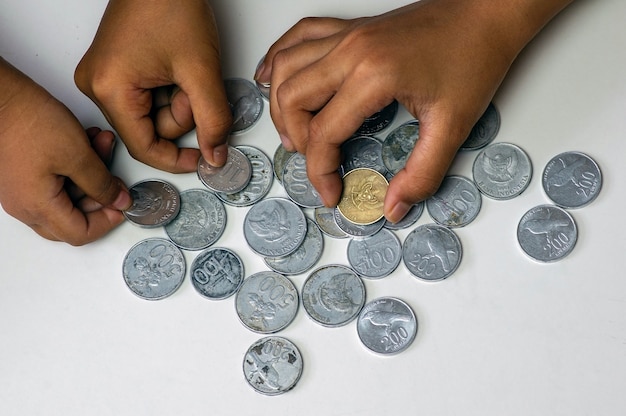 Hands of Indonesian children playing old rupiah coins