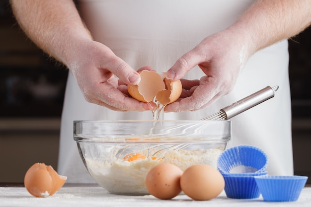 Hands, ingredients and devices for preparation of cup-cakes. House pastries. Food concept. Flour, eggs, butter, mix for pastries