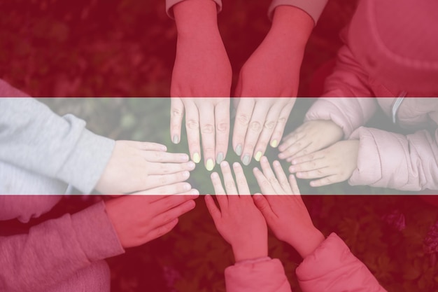 Hands of kids on background of Austria flag Austrian patriotism and unity concept