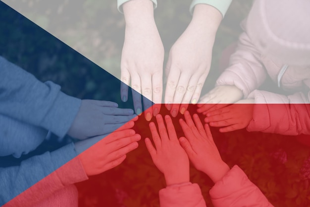 Hands of kids on background of Czech Republic flag Czech patriotism and unity concept