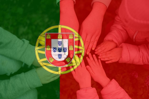 Hands of kids on background of Portugal flag Portuguese patriotism and unity concept