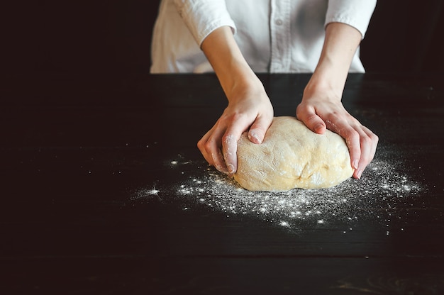 Hands knead the dough