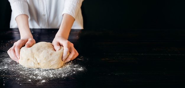 Hands knead the dough