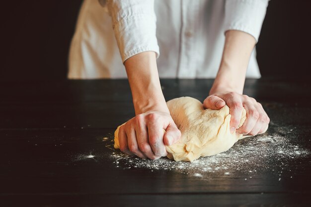 Hands knead the dough