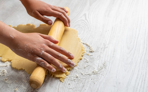 Hands kneading with a rolling pin