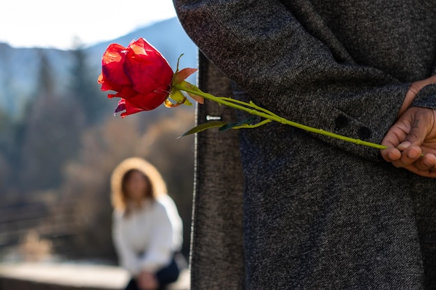 Hands of a latin man in love hiding a rose for his girlfriend Concept of a rose for the girlfriend