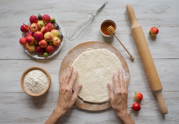 Hands make dough Apple pie or Goji berry. Apple pie for the holiday.