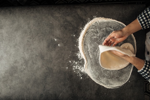 Photo hands making a pizza dough with flour