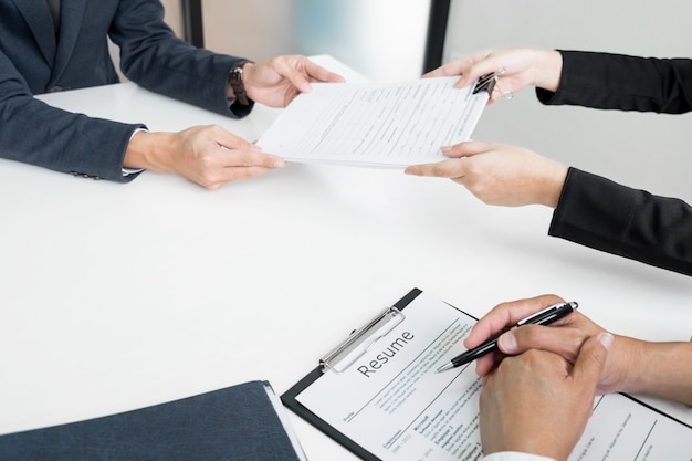 Hands of man giving application portfolio to HR man in office for interview.