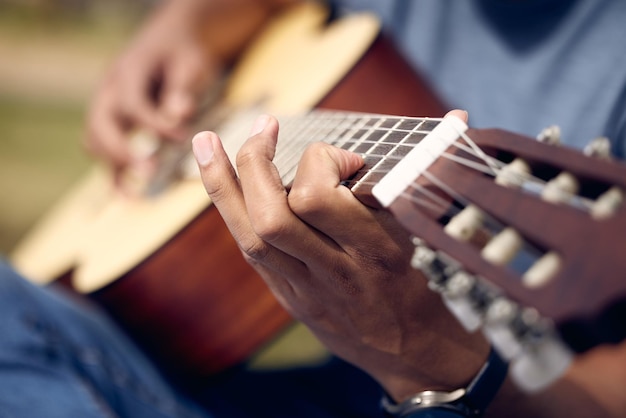 Hands man and playing guitar in garden for music sound and performance in nature Male person musician and instrument in backyard for practice production and rehearsal for talent show in park