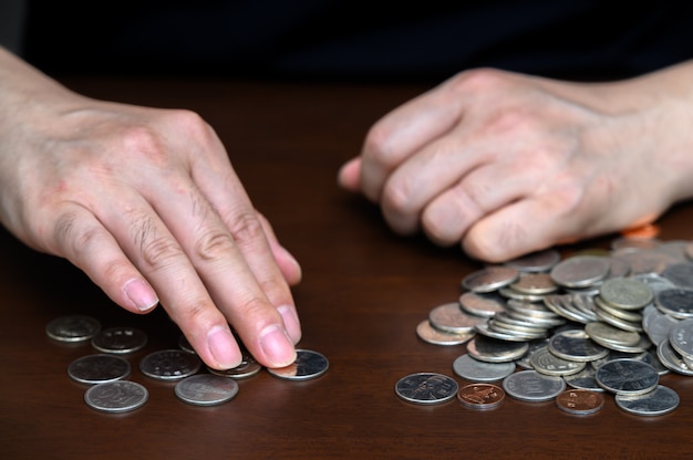 the hands of a man sorting stacked coins.