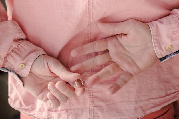 Hands of a man who took off a golden wedding ring behind back having come to his mistress