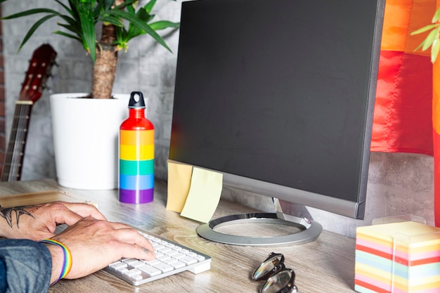 The hands of the man who works in the office with LGBT accessories