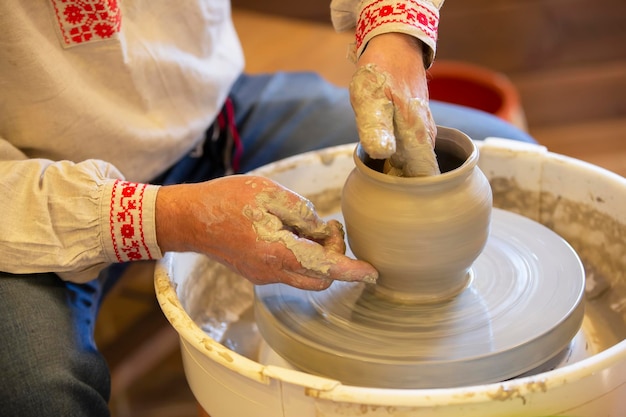 The hands of the master make a pot of clay