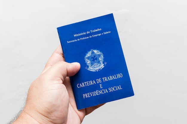 Hands of middle-aged man holding work book, Brazilian social security document