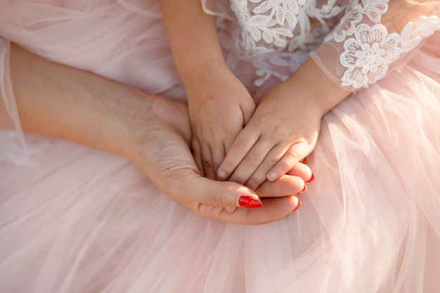 Hands of mom and daughter