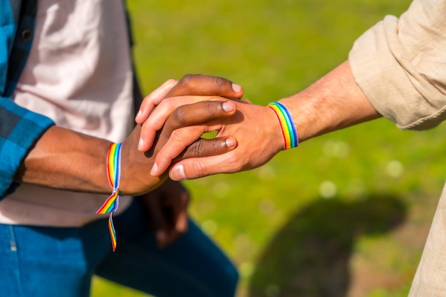 Hands of a multiethnic gay male couple holding hands lgbt concept homosexual guys