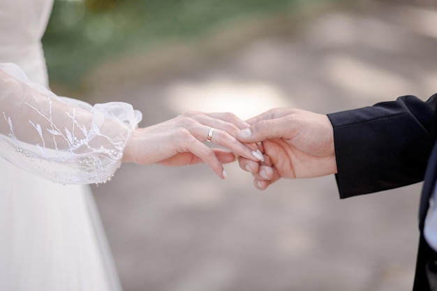 Hands of newlyweds closeup The groom holds the brides hands loving couple holding hands while w