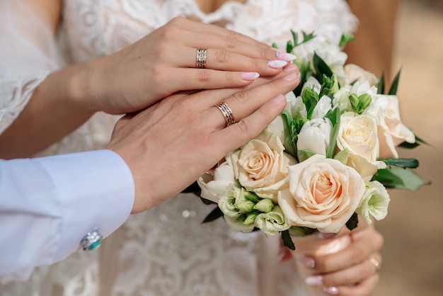 Hands of newlyweds with wedding rings