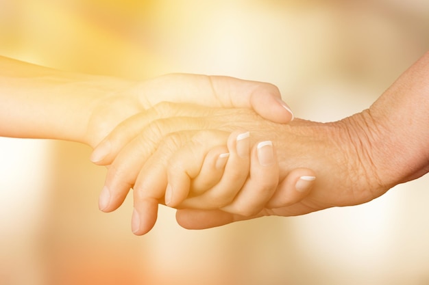 Hands of the old man and a young woman. close up.