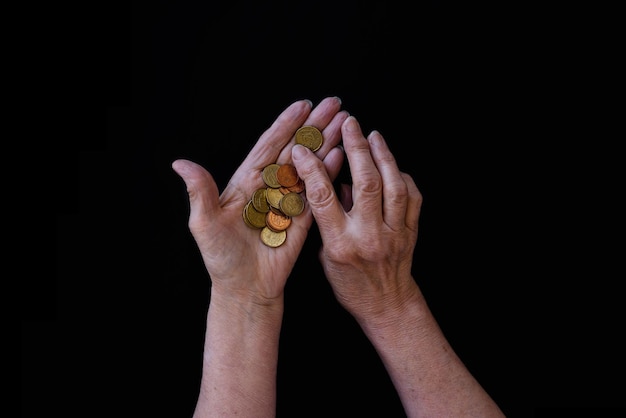 The hands of old woman count the last money cents Black background copy paste