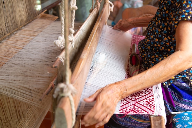 The hands of old woman weaving, the ancient weaving method.