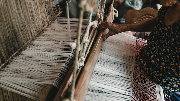 The hands of old woman weaving, the ancient weaving method.