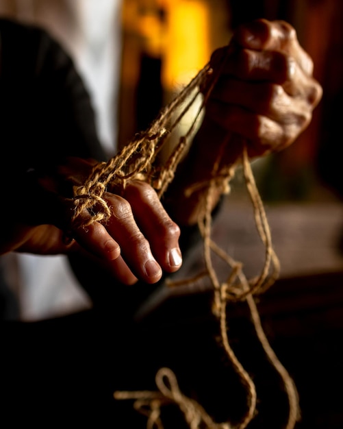 Hands of old woman with polyarthritis disease Canvas strings on fingers of elderly lady puppets