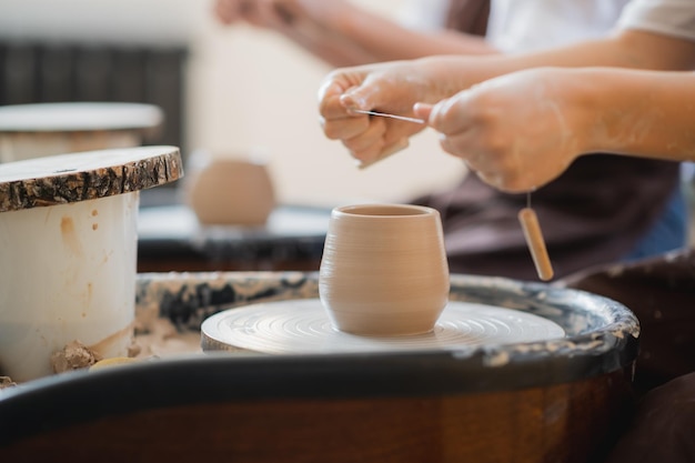 Hands of a potter creating an earthen jar on the circle