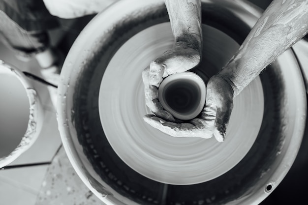 Hands of a potter Potter making ceramic pot on the pottery wheel