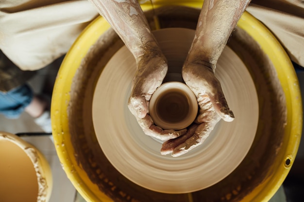 Hands of a potter Potter making ceramic pot on the pottery wheel