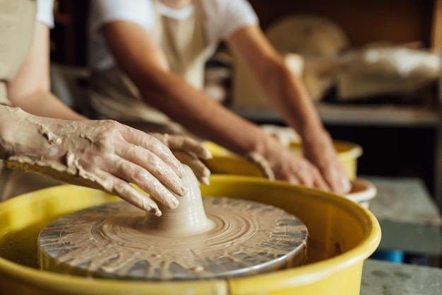 Hands of a potter Potter making ceramic pot on the pottery wheel