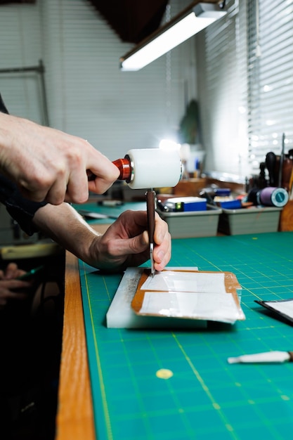 Hands of a professional craftsman make a leather wallet new clean genuine leather wallet closeup cropped shot