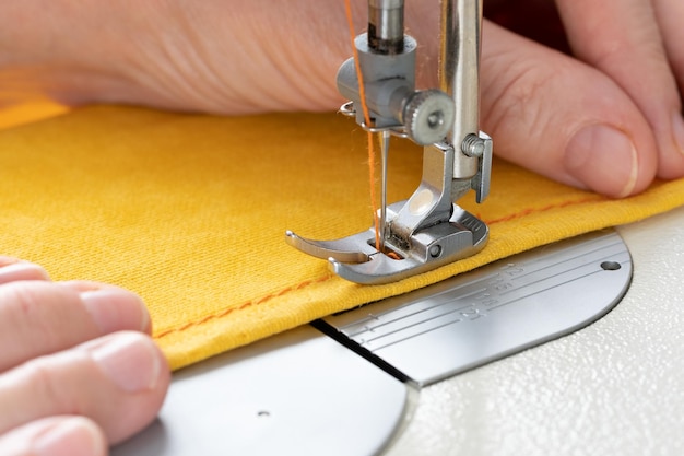 Hands of seamstress sewing with a professional machine Concept of Factory Home